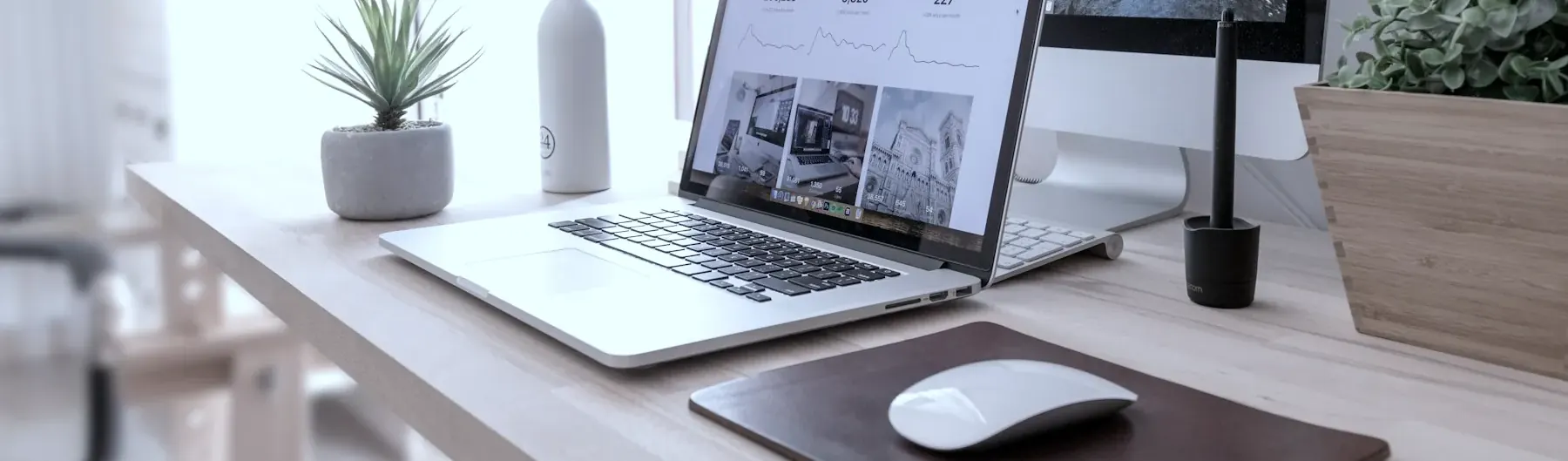 Arbeitsplatz mit Laptop und Monitor, darauf ein Webentwurf